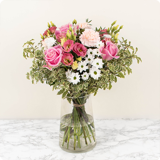 Composé de belles roses et de délicates fleurs de saison dans les tons roses et blancs